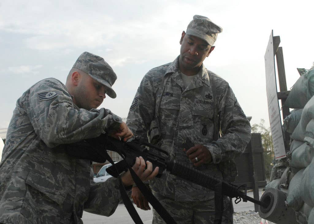 Staff Sgt. Jeremy Nabors (left), a propulsion technician from the 455th Expeditionary Aircraft Maintenance Squadron, clears his weapon. (U.S. Air Force photo)