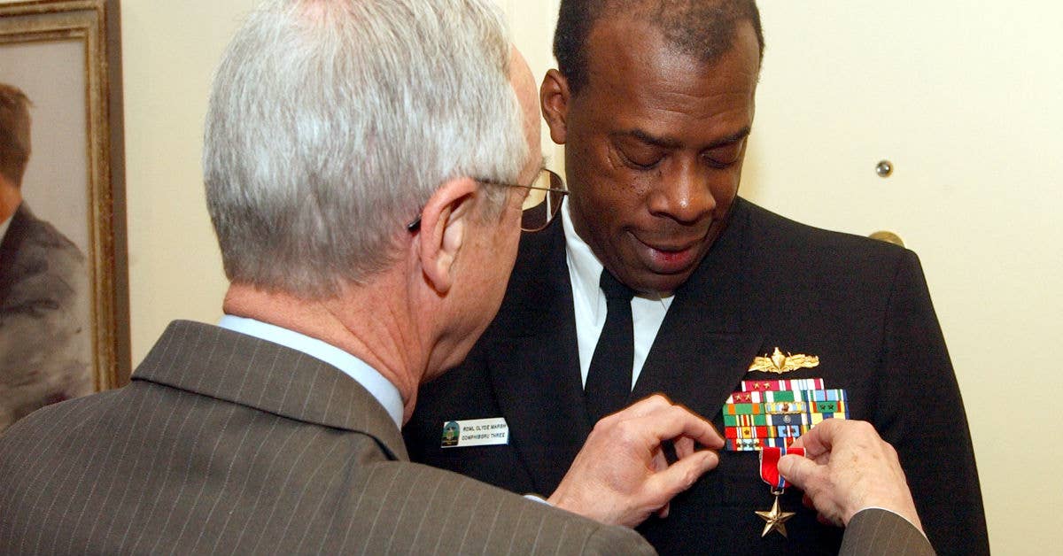 Former Secretary of the Navy Gordon R. England pins the Bronze Star on Rear Adm. Willie C. Marsh during a ceremony held in the Secretary's Pentagon office. Marsh was recognized for meritorious achievement in his duties as Commander, Task Force 51, from January 1, 2003 to May 31, 2003. US Navy photo.