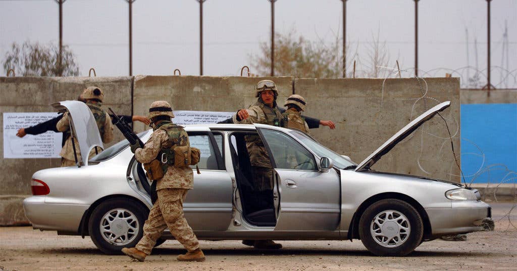 Marine conduct a vehicle checkpoint while in Afghanistan. (Source: Wikipedia Commons)