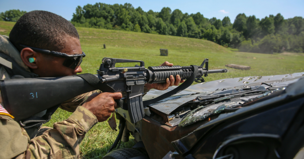 U.S. Army Staff Sgt. Qujuan Baptiste uses a vehicle as a barricade and fires at multiple targets during a stress shoot scenario at the 2017 Army Materiel Command's Best Warrior Competition July 18, 2017, at Camp Atterbury, Indiana. (U.S. Army photo by Sgt. 1st Class Teddy Wade)