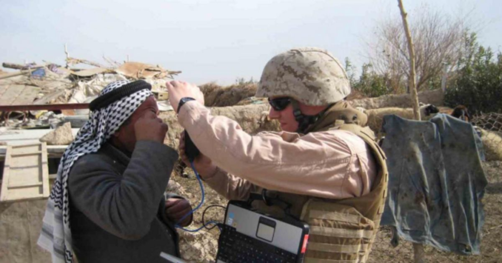 A Marine scans a local national in the field. (Source: Wikipedia Commons)