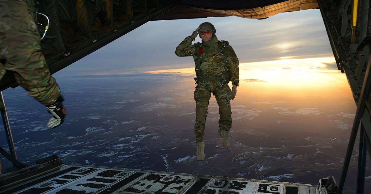A US Soldier assigned to 1st Battalion, 10th Special Forces Group salutes his fellow Soldiers while jumping out of a C-130 Hercules aircraft over a drop zone. Army photo by Visual Information Specialist Jason Johnston