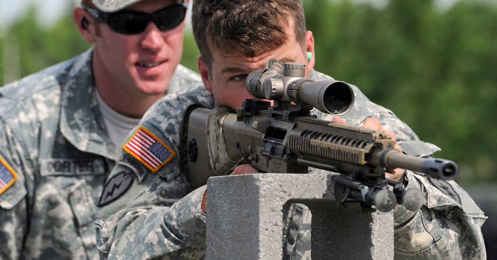 Spc. Anthony Tramonte, lines up a target as Army Staff Sgt. Kevin Corter coaches him during the final day of M110 Semi-Automatic Sniper System (SASS) qualifications at Joint Base Elmendorf-Richardson's Grezelka Range, July 10, 2013. (U.S. Air Force photo/Justin Connaher)