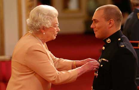 Her Majesty The Queen presents Matthew Croucher with his George Cross.
