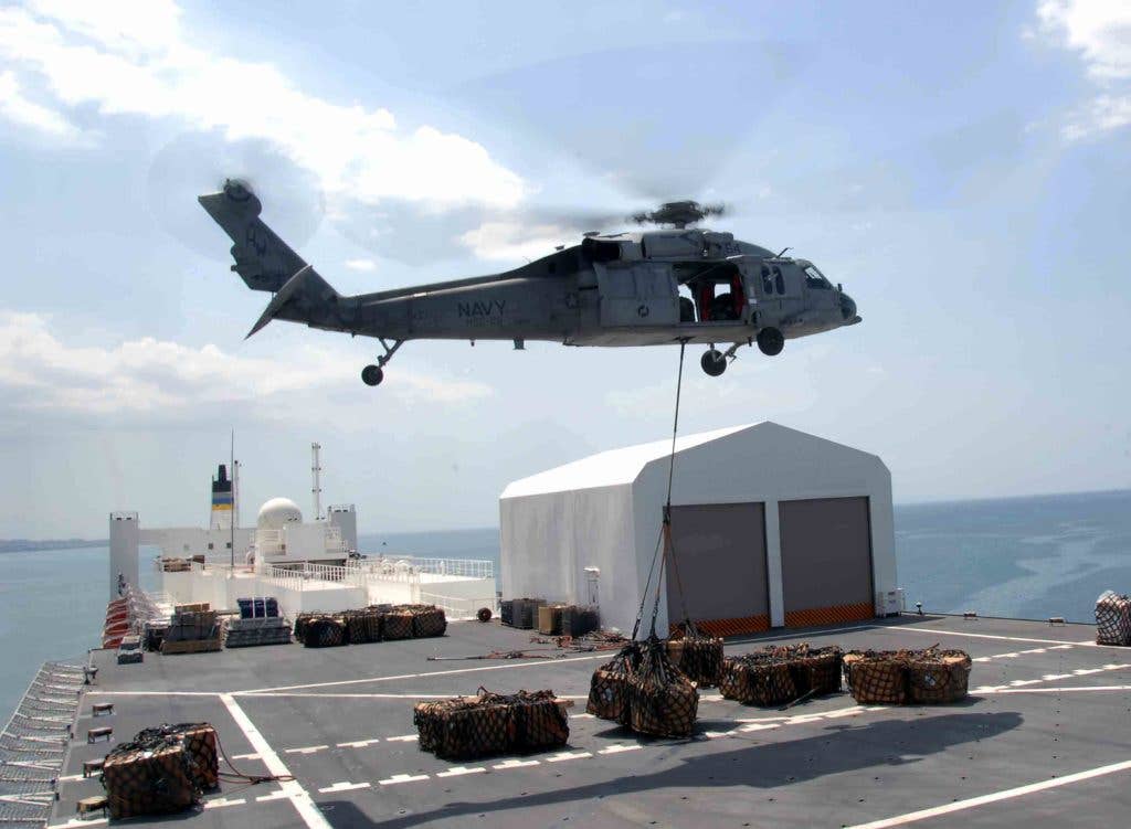 A MH-60S Sea Hawk helicopter carries one of the 333 loads of cargo from the Military Sealift Command hospital ship USNS Comfort (T-AH 20) as the ship is anchored offshore near Port-Au-Prince. (U.S. Army photo by Spc. Eric J. Cullen/Released)
