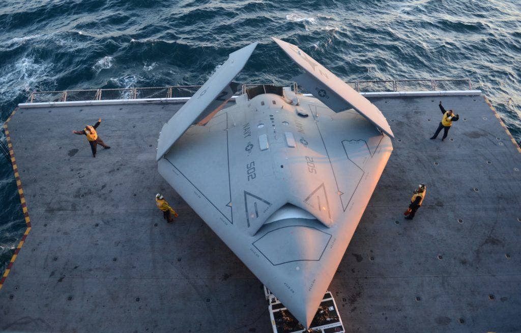 An X-47B demonstrator with folded wings on the aircraft elevator of USS George H.W. Bush. (US Navy photo by MC2 Timothy Walter)