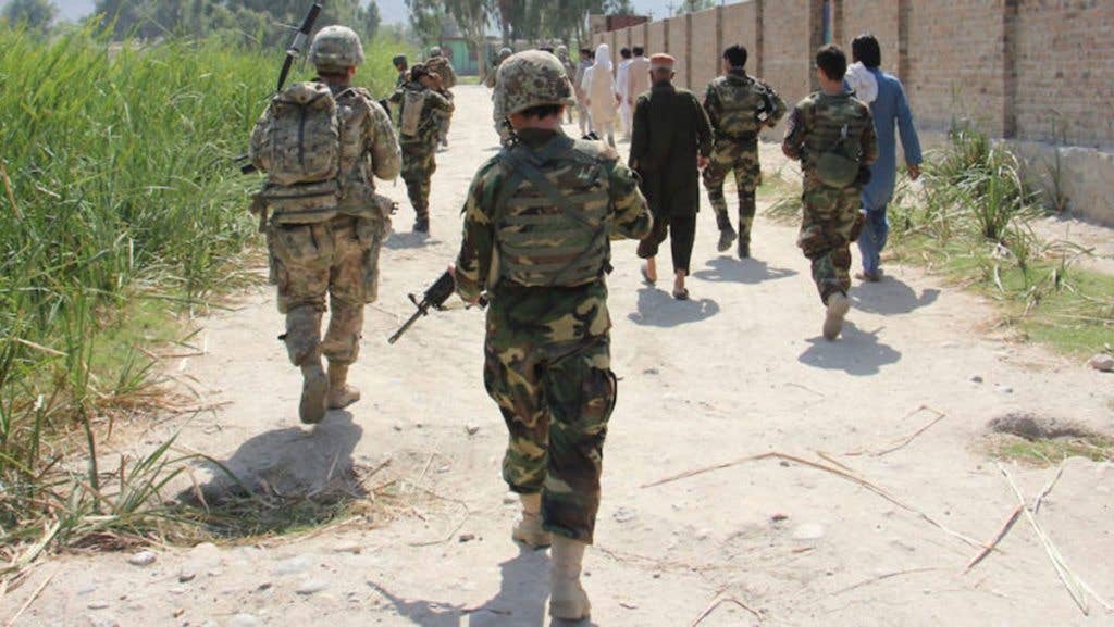American soldiers patrolling near afghan civilians