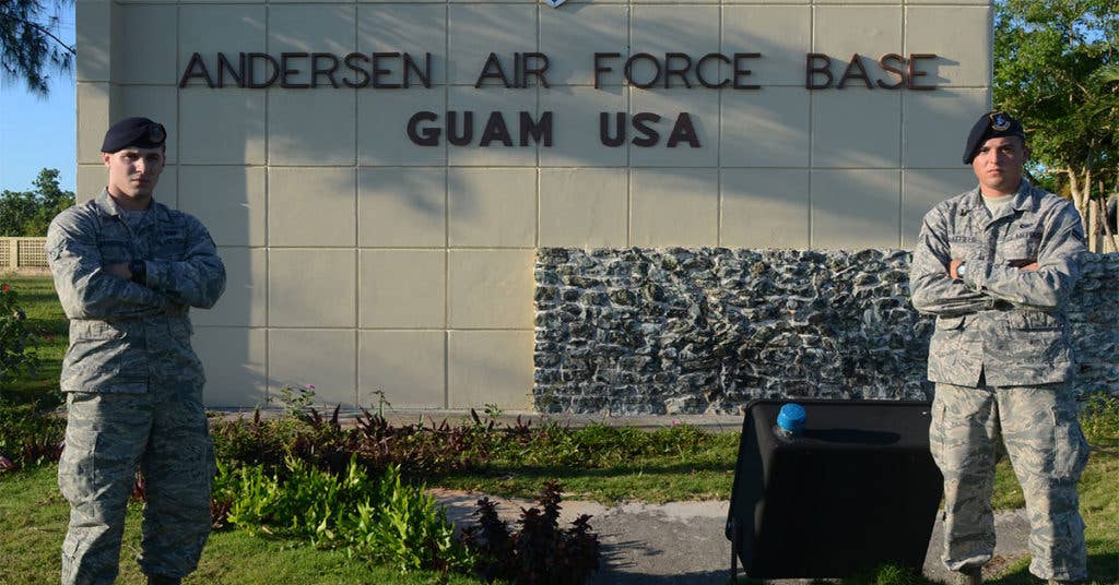 Two Airmen stand with pride in front of Andersen Air Force Base (Source: DoD)