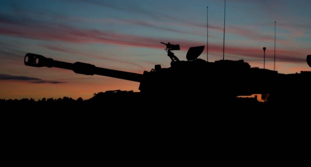 An M109A6 Paladin with Bravo Battery, 3rd Battalion, 29th Field Artillery Regiment (Pacesetters), 3rd Armored Brigade Combat Team, 4th Infantry Division waits for darkness before the night live-fire portion of the table six gunnery certification. (U.S. Army photo by Capt. John W. Strickland)