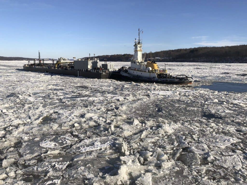 Coast Guard Cutter Penobscot Bay helps break free tug Brooklyn from the ice on the Hudson River near Saugerties, New York, December, 31 2017. Coast Guard ice-breaking tugs from New Jersey and New York are positioned along the river and are assisting vessels transiting areas where thick ice is present. (U.S. Coast Guard photo courtesy of Coast Guard Cutter Penobscot Bay)