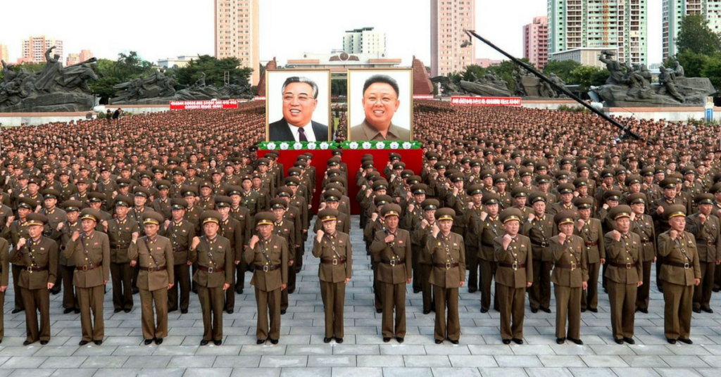 Members of the North Korean military stand in front of photos of Kim Il Sung and Kim Jong Il (Image KCNA Watch)
