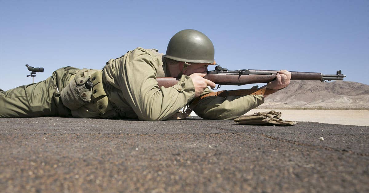 Brandon Ryder, shooter, Apple Valley Gun Club, fires an M1 Garand while wearing World War II era Army attire during the D-Day Match sponsored by the High Desert Competitive Shooting Club at the Combat Center Rifle Range, June 6, 2015. The D-Day invasion was the largest amphibious assault by Allied Forces in history. (Official Marine Corps photo by Lance Cpl. Thomas Mudd)