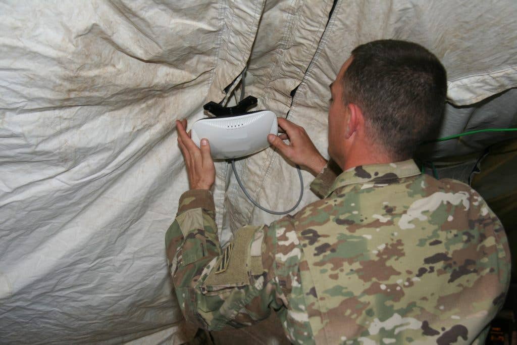 A Soldier from the 1st Armored Brigade Combat Team, 3rd Infantry Division sets up a secure Wi-Fi Access Point in the brigade main command post as part of a pilot of the capability during the unit's training rotation at the National Training Center, at Fort Irwin, California, in April 2017. (Photo Credit: U.S. Army photo by Amy Walker, PM Tactical NetworkPEO C3T Public Affairs)