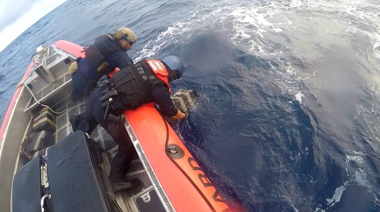 A Coast Guard Cutter Mohawk boat crew pulls bales of cocaine from the water during a 53-day Eastern Pacific counter-drug patrol. The cutter Mohawk seized more than three tons of cocaine on the patrol. (Coast Guard photo)