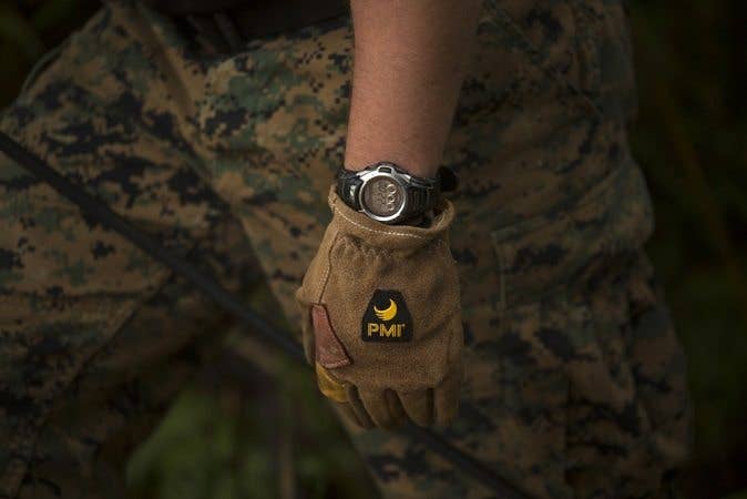 A marine displays a wristwatch. A watch is critical to the useful gear list. 