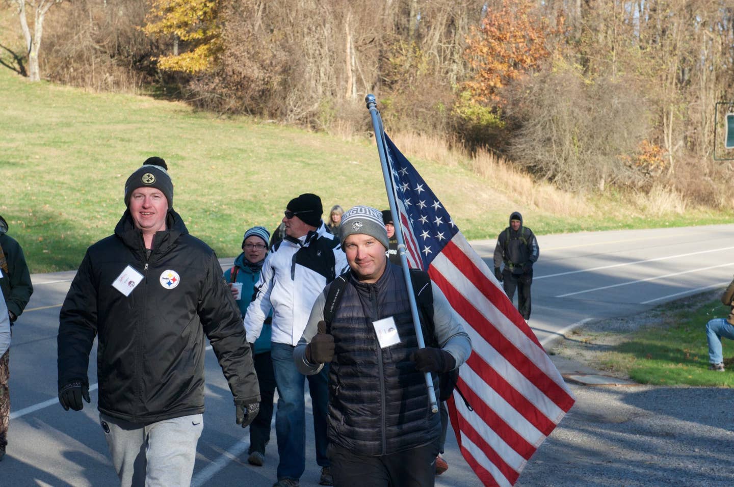 Bryan Watson, secretary for the Defenders of Freedom Pittsburgh, a nonprofit organization out of Pittsburgh, Pennsylvania, carries the American flag and leads volunteers during the 2nd Annual Stop 22 Ruck March, at North Park in Allison Park, Pennsylvania on November 11, 2017. The ruck march is held on Veterans Day to raise awareness about veteran suicide. (U.S. Army Photo by Spc. Miguel Alvarez, 354th Mobile Public Affairs Detachment)