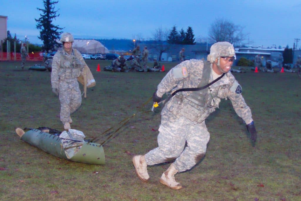 A Soldier with 1-2 Stryker Brigade Combat Team drags a simulated casualty to the finish line of Objective Bull Dec. 15, 2017, at Joint Base Lewis-McChord, Washington. Objective Bull was the final event of the Expert Infantry Badge testing, which was held Dec. 11-15. (Photo Credit: U.S. Army photo by Staff Sgt. Samuel Northrup)