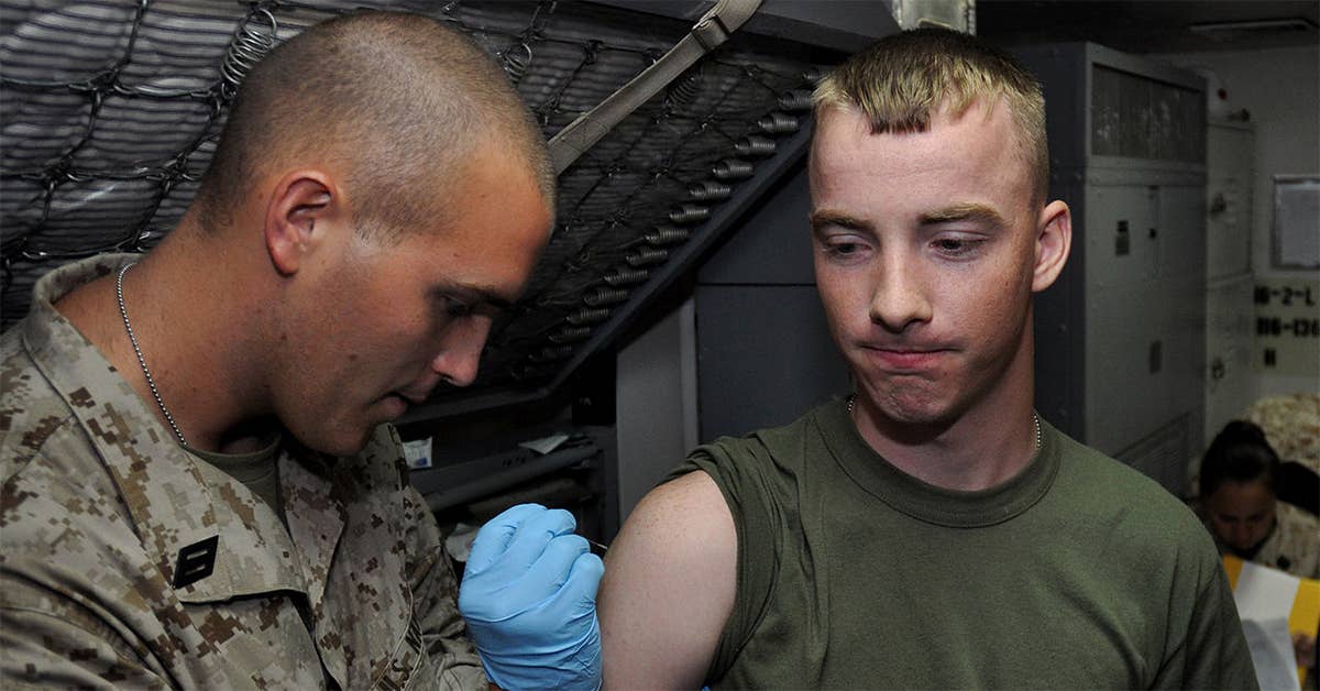 LCpl. Daniel Breneiser, right, gets vaccinated against smallpox by HN Nathan Stallfus aboard USS Ponce before heading out. (Photo from U.S. Navy)