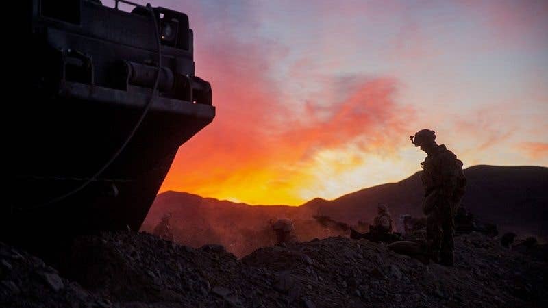 Marines around their fighting positions as the sun rises (Image via Army Times)