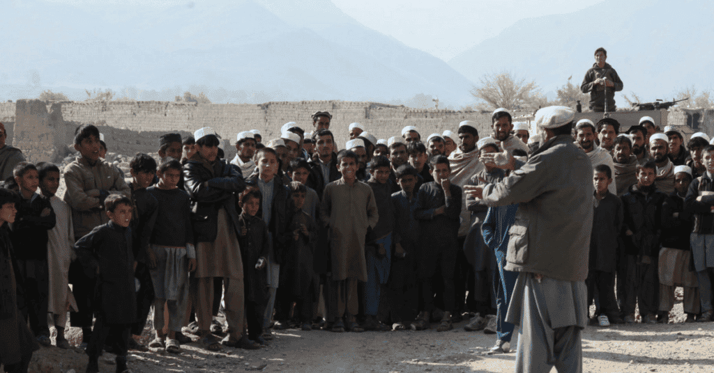 An Afghan village elder directs a crowd of eager school children as Afghan Special Security Forces arrive to distribute school supplies in Shadel village, Nangarhar province, Afghanistan, Dec. 3, 2017. ASSF drove ISIS from the village during fall offensive operations, allowing the locals to regain their farmland and re-open schools. (U.S. Army photo by Staff Sgt. Matthew Klene)