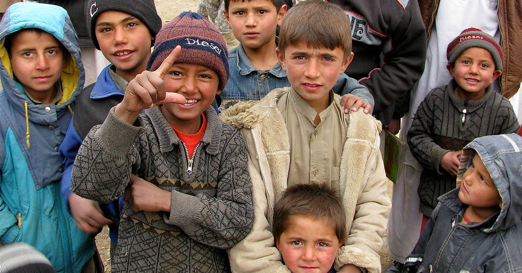 Afghan kids take a moment to smile for the camera. (Image from Wikimedia Commons)