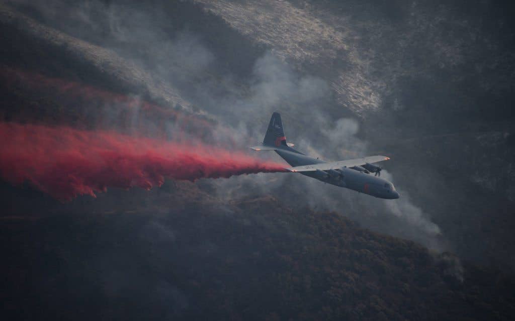 A C-130J Hercules from the 146th Airlift Wing, California Air National Guard, sprays fire retardant ahead of the leading edge of the Thomas Fire, Dec. 13, 2017. The 146th was activated to support CAL FIRE with wildfire suppression efforts within the state. The C-130s from Channel Islands Air National Guard Station are capable of spraying fire retardant from a modular airborne firefighting systems loaded in the cargo bay. (U.S. Air Force photo by Master Sgt. Brian Ferguson)