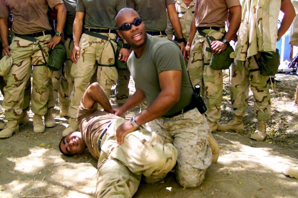 Marine Sgt. Shawn Brown shows the proper armlock technique during a guard training class to the Royal Tongan Marines.