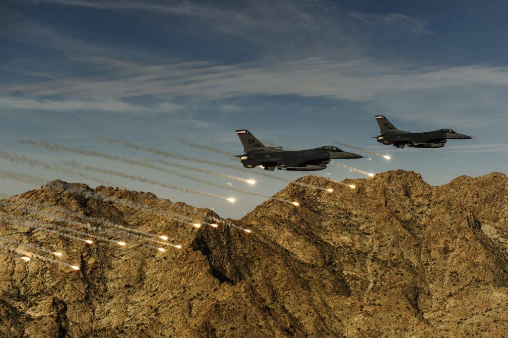 Two F-16C Fighting Falcons release flares while conducting low-level combat training during the Coronet Cactus exercise near Davis-Monthan Air Force Base, Ariz. The F-16s are assigned to the , assigned to the 182nd Fighter Squadron. This exercise provides realistic combat training for student fighter pilots from air-to-air combat to dropping inert and live ordnance. (U.S. Air Force photo by Staff Sgt. Jonathan Snyder)