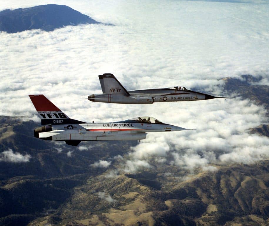 An air-to-air right side view of a YF-16 aircraft and a YF-17 aircraft, side-by-side, armed with AIM-9 Sidewinder missiles. (U.S. Air Force Photo)