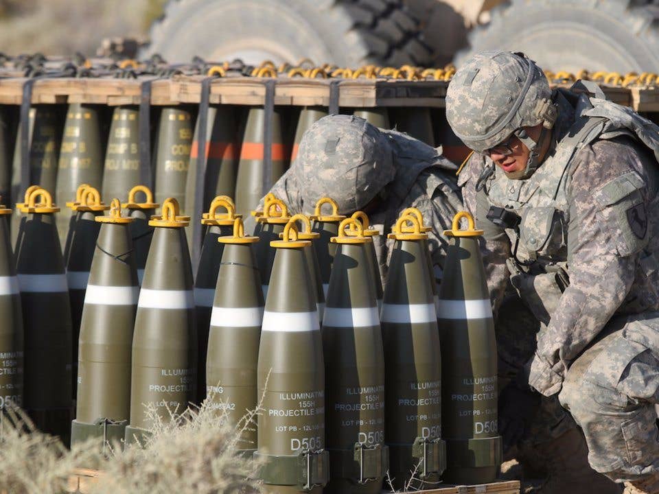Illuminating projectiles, each weighing close to 100 pounds, are staged by Pfc. Juan Valenzuela and others from the California Army National Guard's 1st Battalion, 144th Field Artillery Regiment July 21 at National Training Center, Fort Irwin, California, July 21, 2017. (Army National Guard)