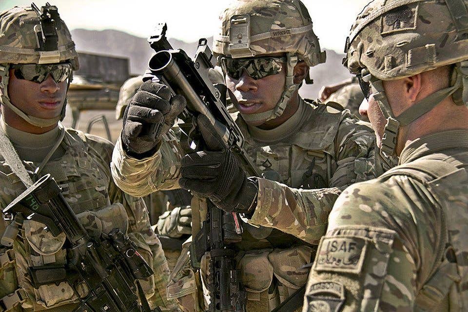 U.S. Army Pfc. Rohan Wright, center, a cavalry scout with a personal security detachment with the 4th Brigade Combat Team, 101st Airborne Division, prepares to fire an M320 Grenade Launcher Module (GLM) at the weapons range at Forward Operating Base Thunder in Paktia province, Afghanistan, Oct. 18, 2013. (US Army photo by Sgt. Justin A. Moeller)