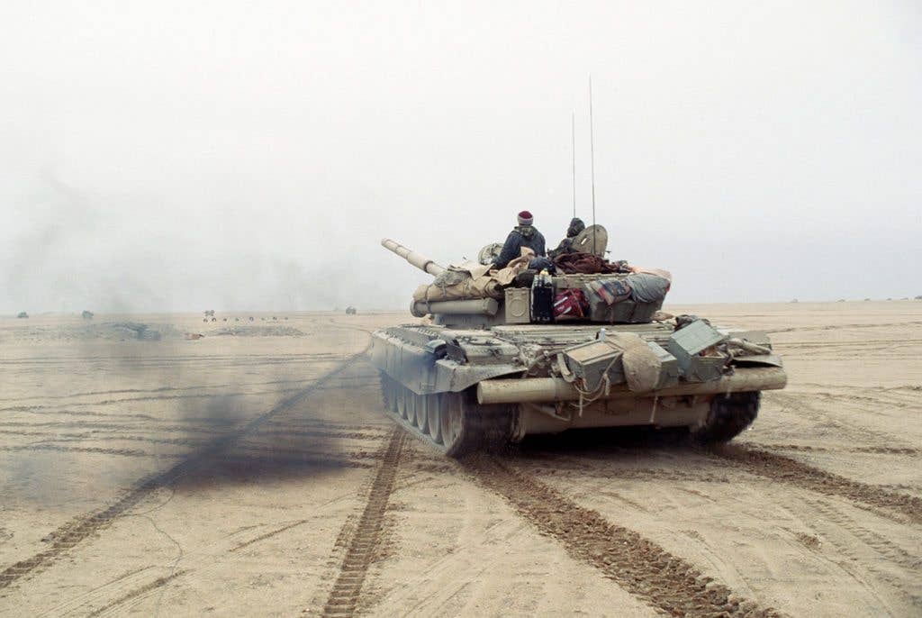 Members of the Coalition forces drive a T-72 main battle tank along a channel cleared of mines during Operation Desert Storm. (DOD photo)