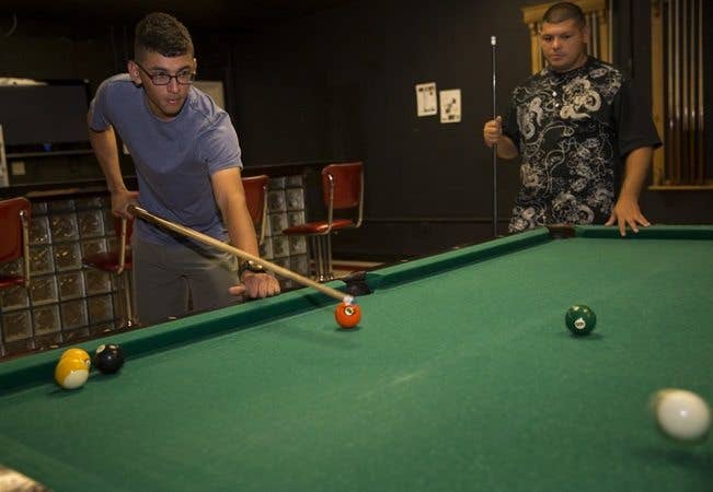 Two soldiers overseas playing pool