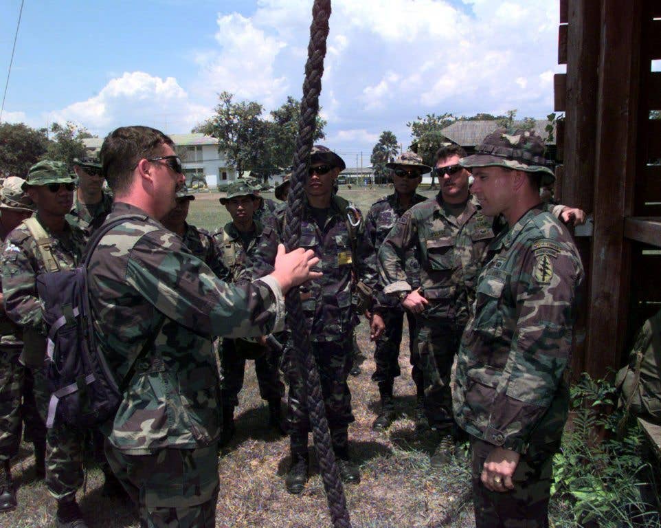U.S. Army Staff Sgt. Sean Suttles (left), and Sgt. 1st Class Keith Looker (right), brief U.S. and Royal Thai Special Forces personnel on safety procedures prior to fast-rope training on May 17, 1998, during Exercise Cobra Gold '98. (DoD photo by Tech. Sgt. Raymond T. Conway, U.S. Air Force)
