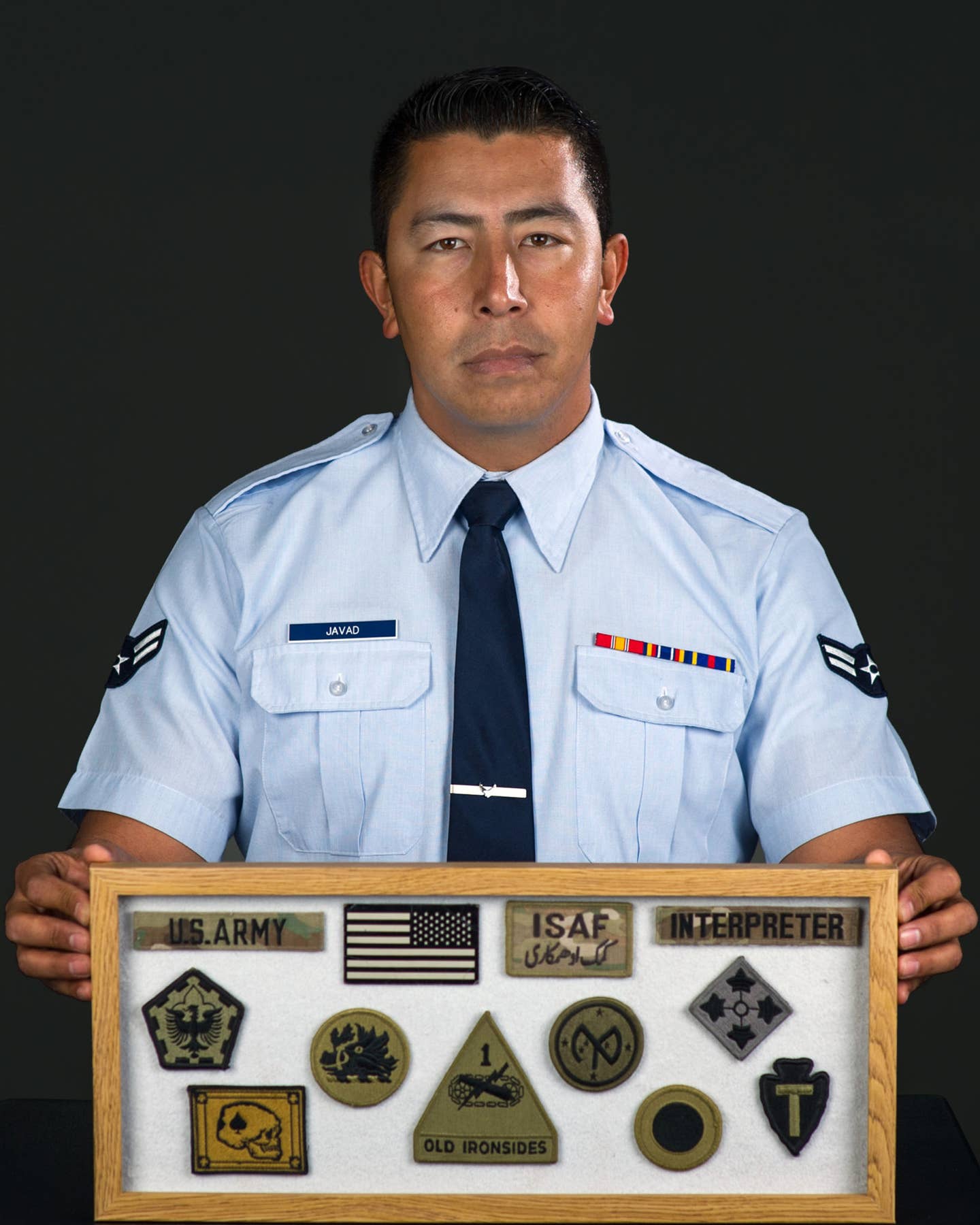 Airman 1st Class Mohammad Javad from the 60th Aerial Port Squadron, Travis Air Force Base, Calif., poses with some keepsakes he collected during his time as a linguist with U.S. forces, March. 6, 2018. (Photo by Louis Briscese)