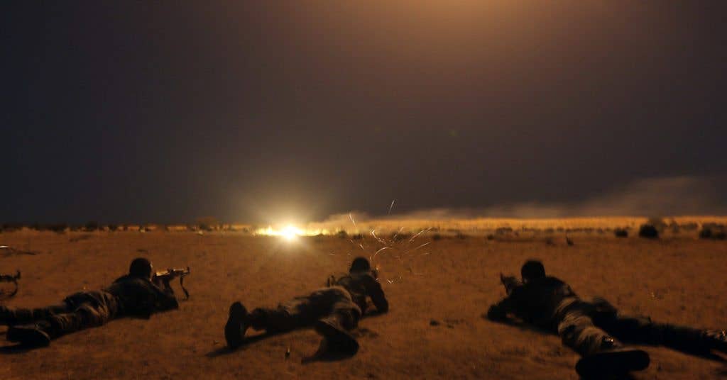 Nigerien army soldiers shoot targets under 60mm illumination mortar rounds.
