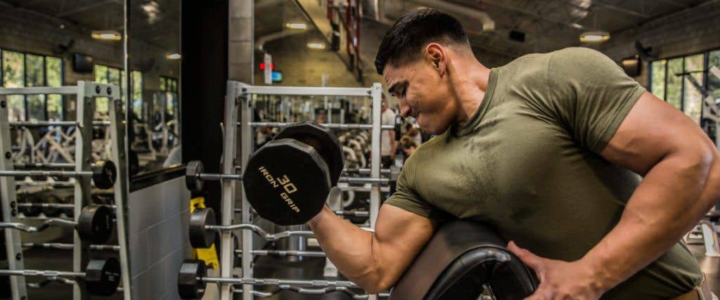 This Marine almost completes his rep during a single-arm preacher curl at one of the 56 fitness centers the Corps provides.