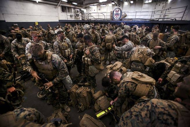 These Marines prep their gear aboard the USS Ashland before heading out.