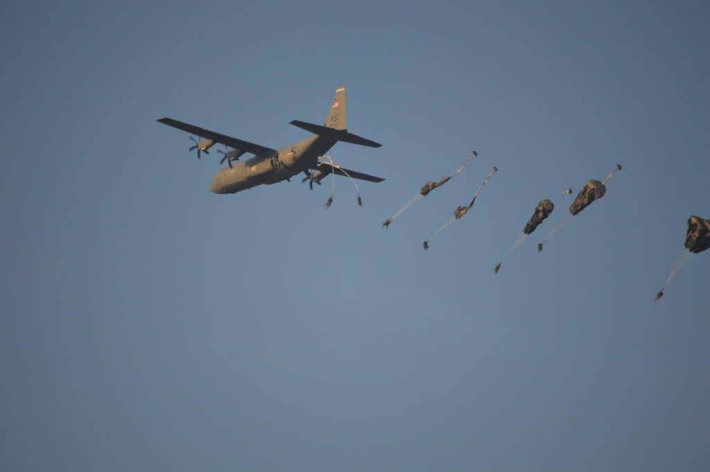 Paratroops from the 173rd Airborne Brigade jump from a C-130 transport. They use static lines to ensure their main chutes open. (DOD photo)