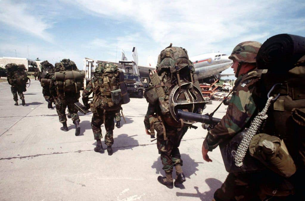 Soldiers of the 10th Mountain Division, Ft Drum, N.Y., dressed in full combat gear, line up to board UH-60 Blackhawk helicopters at Port-au-Prince airport Port-au-Prince, Haiti to take them to Bowlen Airfield during Restore Democracy on 22 Sept 94. (US Army photo)