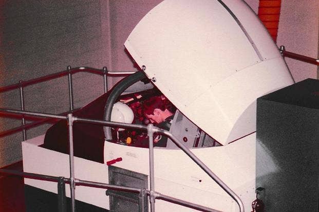 One of Eugene Taylor's trainees at Vance AFB, Oklahoma, straps into a flight simulator, circa 1978-79.