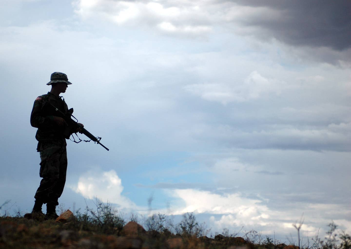 A National Guard Soldier from the 29th Brigade Combat Team, assisting the U.S. Border Patrol, stands watch on a ridge above Nogales, Ariz., at the Mexico border.