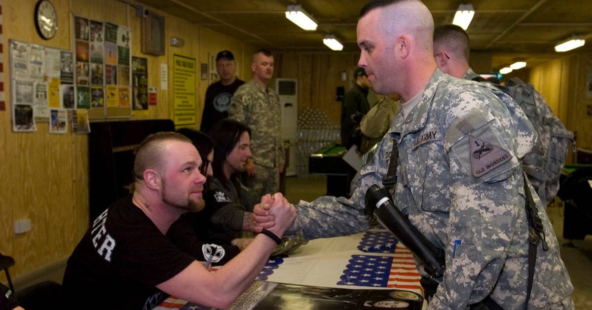 Pfc. John Dothage meets Five Finger Death Punch after they performed for U.S. troops at Camp Stryker, Baghdad, March 3, 2010