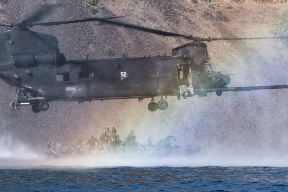 An MH-47 Chinook picks up a special operations Night Stalkers boat crew during training.