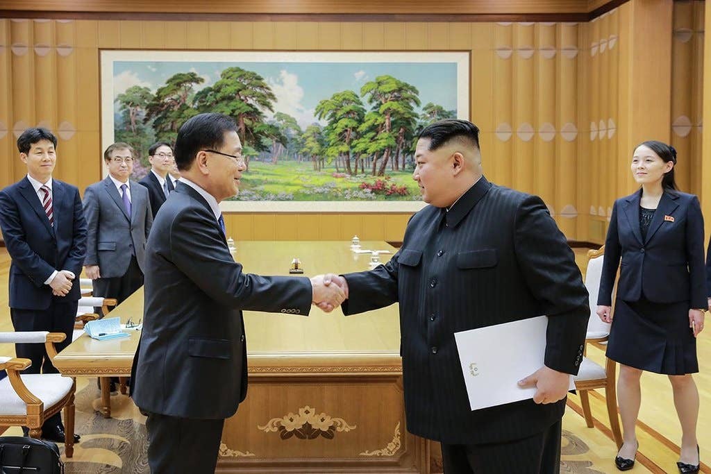 Chief of the National Security Office Chung Eui-yong and North Korean leader Kim Jong-un meetingu00a0in Pyongyang on March 5, 2018; Jong-un is holding a letter signed by SK's president Moon Jae-in to arrange for more talks towards peace.