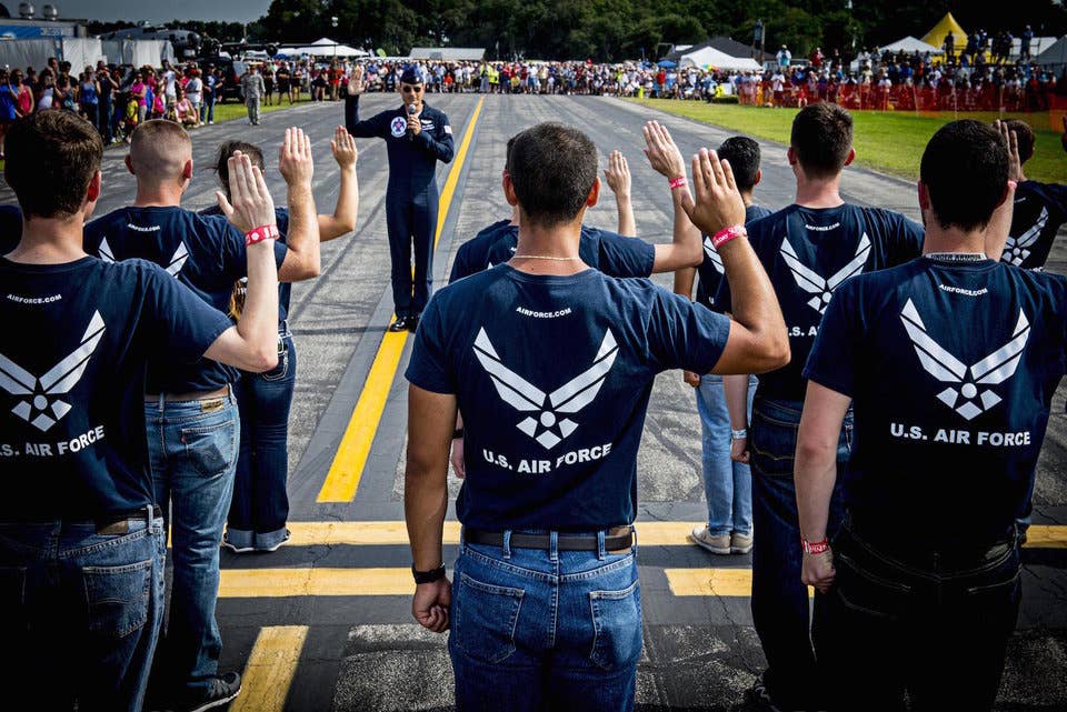 Maj. Tyler Ellison, a Thunderbirds pilot, administers the oath of enlistment to enlist Florida's newest airmen during the Sun 'n Fun International Fly-in and Expo Air Show at Lakeland, Florida, April, 25, 2015.