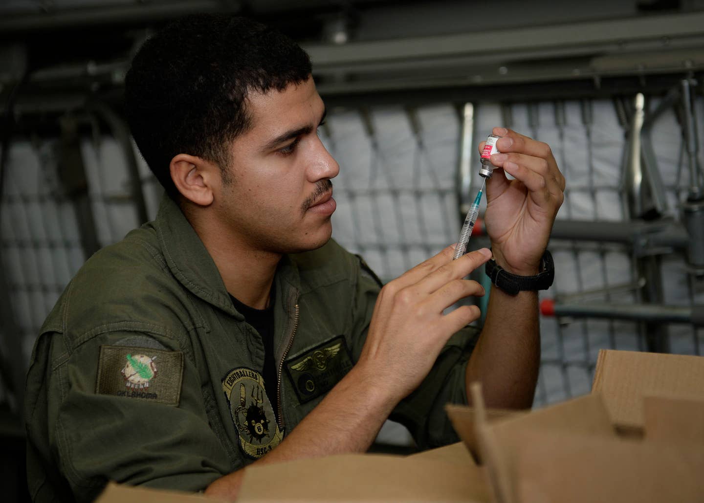 U.S. Navy Hospital Corpsman 2nd Class Josh Ferrell, from Apache, Okla., fills a syringe with anthrax vaccine.
