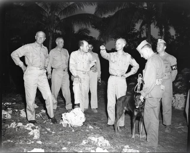 Mr. Pyle is shown here talking to Division Commander, Major General Graves B. Erskine. It is Ernie's first trip into the Pacific. Previously he wrote about GI Joe from the European Theater of Operations. From left to right: Major General Erskine, Lt. Comdr. Max Miller, Col. Robert E. Hogaboom, Ernie
