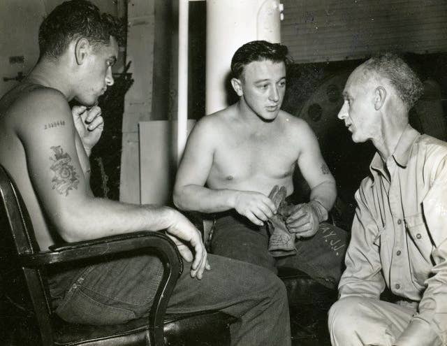 Ernie Pyle, war correspondent, interviewing Joe J. Ray S1/c and Charles W. Page S1/C on board the USS Yorktown (CV-10) / Date: February 5, 1945