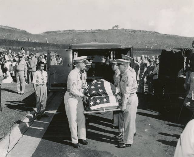 The body of Ernie Pyle, who lost his life while serving with first line troops on Ie Shima, was laid to final rest on July 19th in the new Punchbowl Memorial Cemetery of the Pacific, Oahu. Pall bearers are pictured removing Ernie Pyle's flag draped casket before the burial ceremonies / Date: July 1